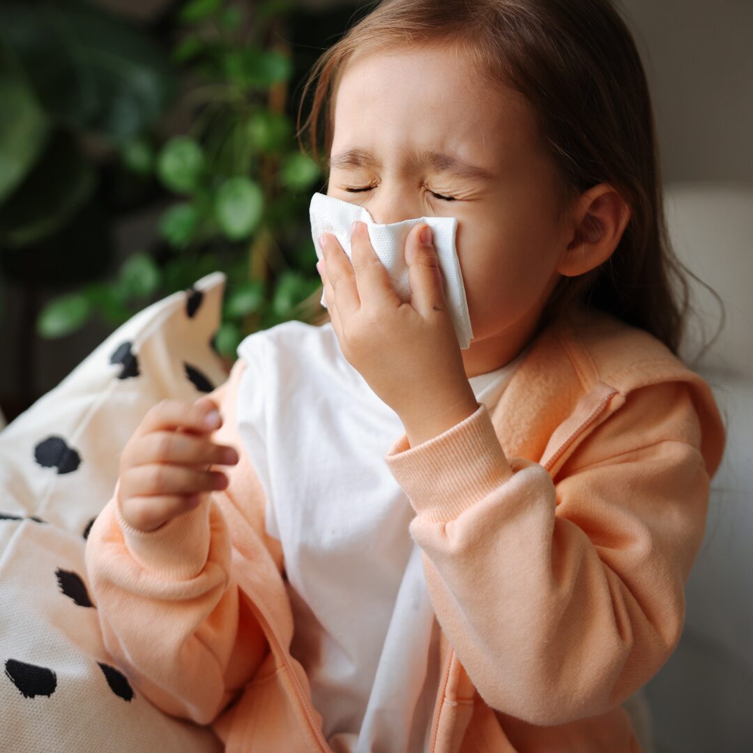 A child catching a sneeze with a tissue