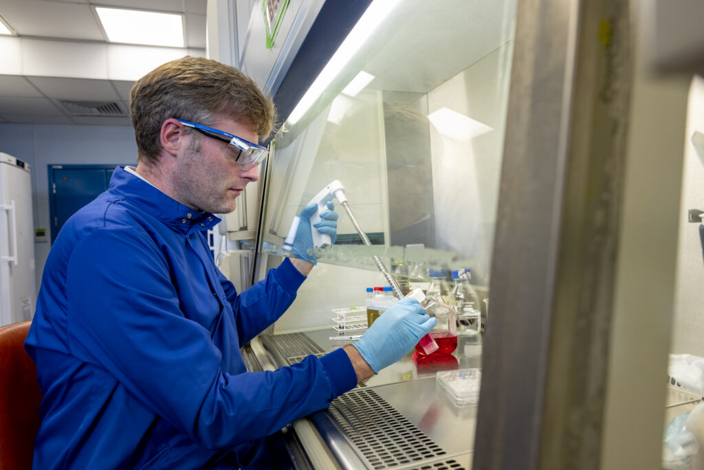 A researcher in a laboratory holding a test tube and conducting experiments.
